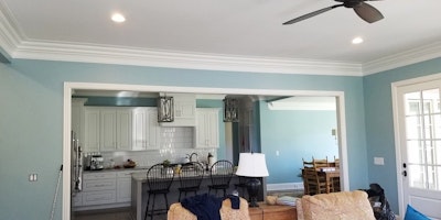 Blue living room and kitchen with white cabinets and trim - Residential painting