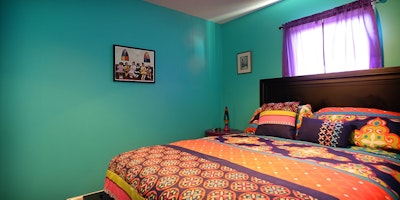 Teal walls against multicolored bed spread - Residential painting by Nash Painting Nashville TN